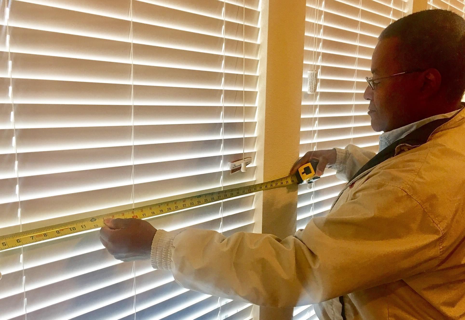 Man Measuring Windows For Window Shades Treatment