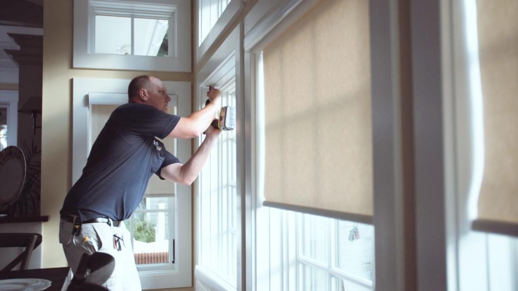Man Installing Automated Shades In A Living Room